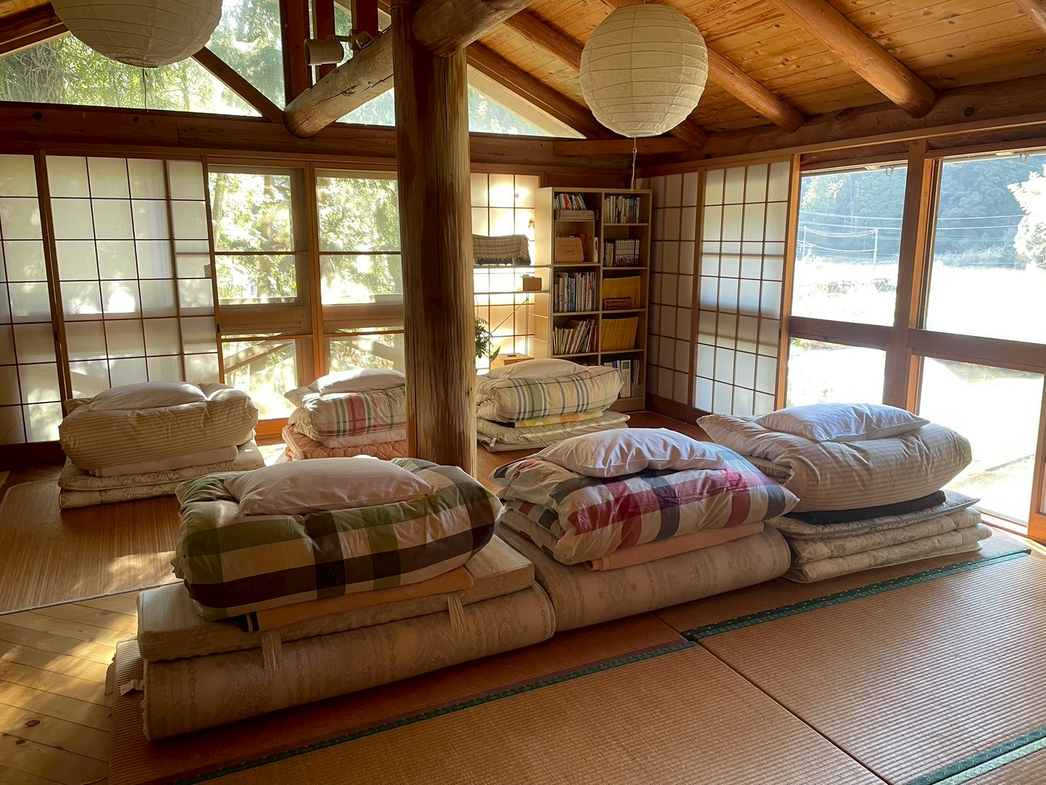 夕日の差し込む大広間。お布団を並べてみんなで一泊